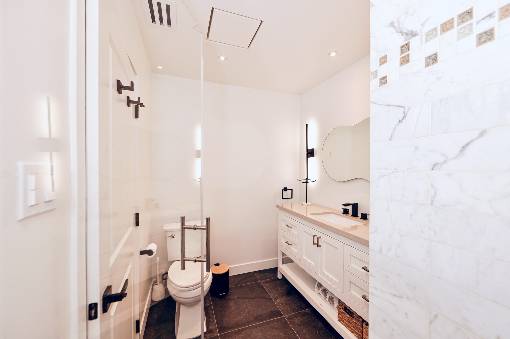 Guest bath with custom Carrera marble shower and matte black hardware