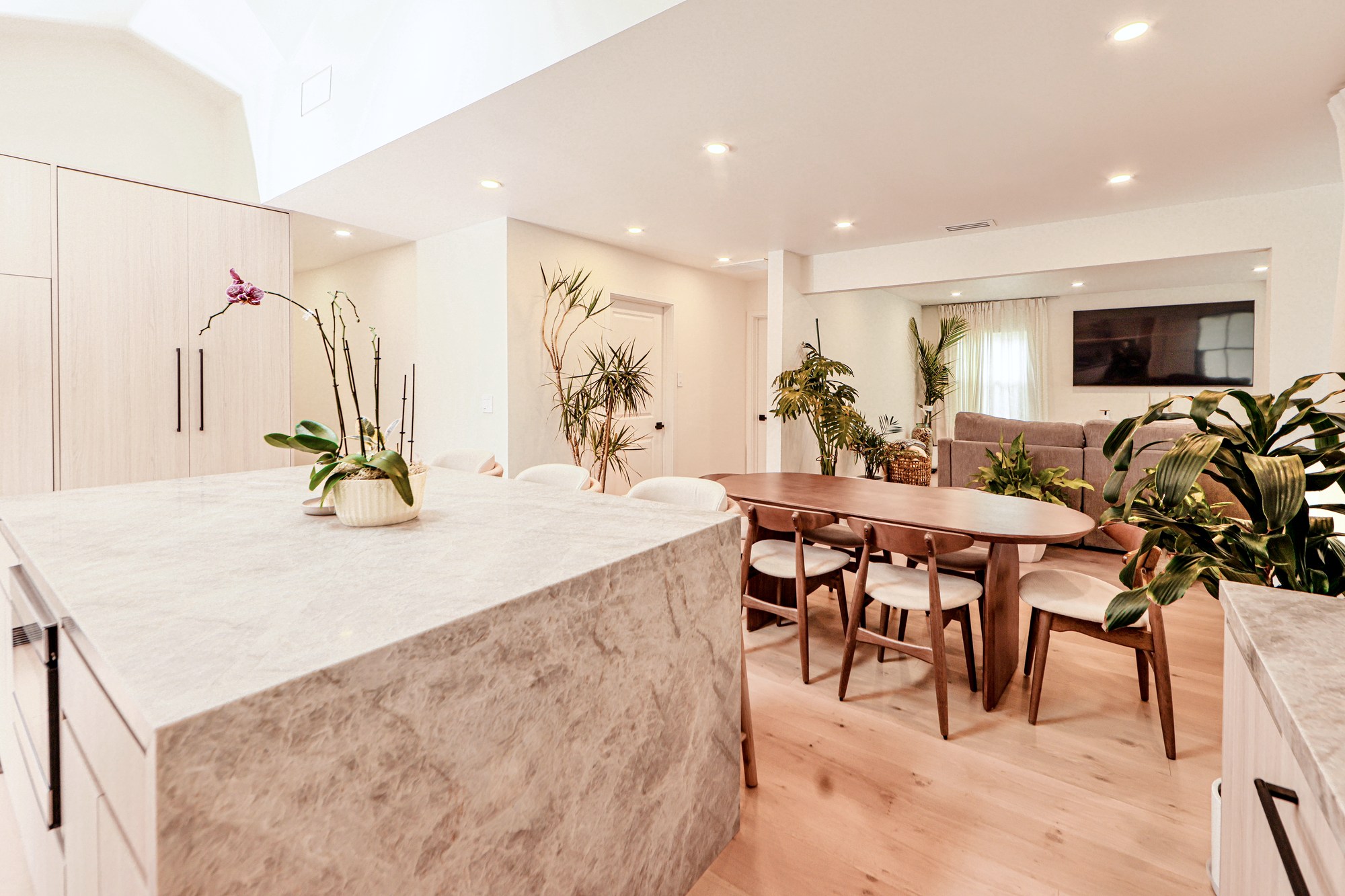 Vaulted, skylit kitchen great room with maple cabinetry and stone counters
